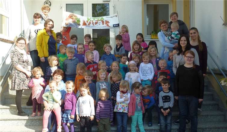 Stolz präsentieren die Kinder und Erzieherinnen der Kita „Löwenzahn“ das Zertifizierungsbanner „Kita-Vital“.Stadt Meckenheim