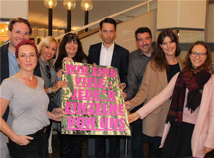 Stolz präsentieren die Unterzeichner das Motto-Plakat