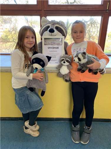 Stolz präsentieren die „Waschbären“ der Schillerschule Lahnstein die Urkunde für die Patenschaft ihrer Namensgenossen im Tierpark.  Foto: Stadtverwaltung Lahnstein