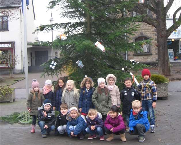 Stolz präsentieren die zukünftigen Schulkinder den geschmückten Baum auf dem Kirchplatz. privat