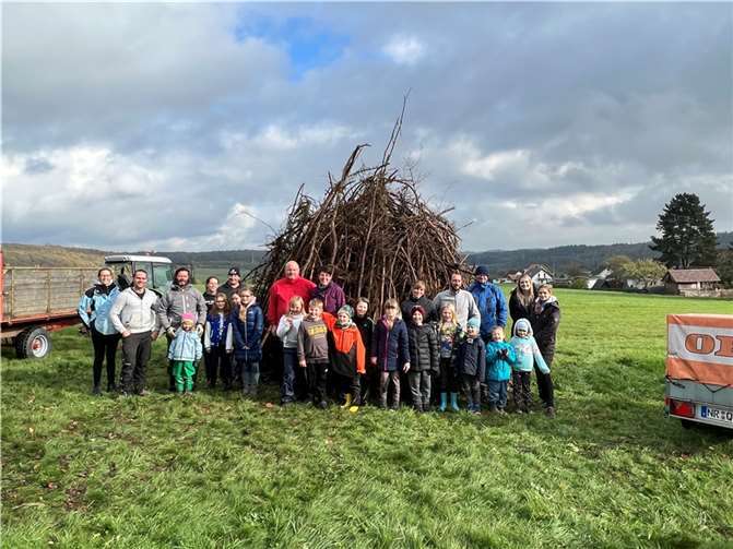 Stolz präsentieren sich Kinder und Erwachsene vor dem Martinsfeuer.