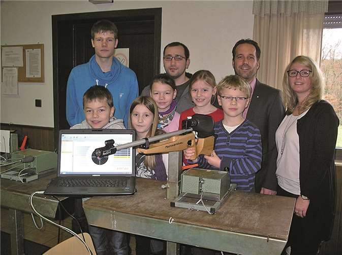 Stolz präsentieren und testen einige „Nachwuchs-Schützen“ das neue Lasergewehr (vorne v.l.): Tom Graziola, Kiara Paffhausen, Miriam Müller, Lea Warzecha und Tobias Müller. Die Vertreter der Raiffeisenbank Neustadt (re.) Sabrina Runkel und Bastian Hallerbach sowie der Jungschützenmeister Rico Ewenz und der Schießmeister Michael Stüber freuen sich mit dem Schützennachwuchs.privat