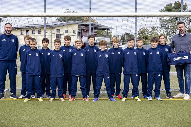 Stolz tragen die Spieler ab sofort die neuen Anzüge, die von Toni Rheinard (rechts im Bild) beim Training überreicht wurden.