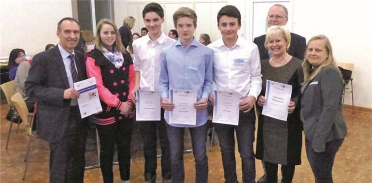 Stolz zeigen die Sieger Erik Siemund, Tobias Schamel und Felix Keune ihre Urkunden, die Wirtschaftsjunioren und Kollegiumsmitglieder freuen sich ebenfalls. WM