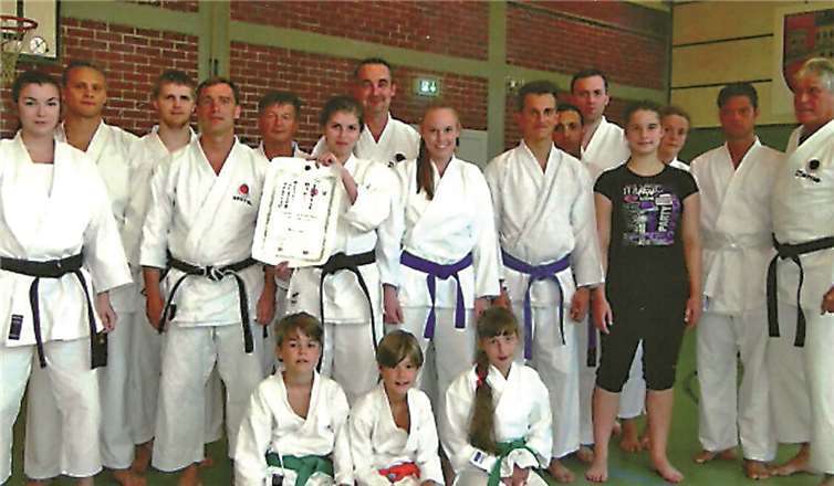 Stolz zeigt Miriam Gast im Kreis ihrer Karatekas ihre Urkunde vor.privat