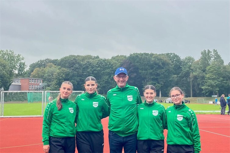 Strahlende Athletinnen mit Trainer