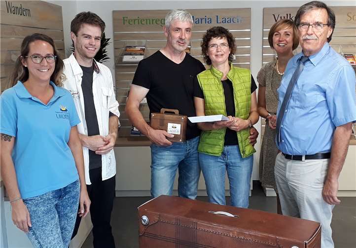 Strahlende Gesichter! Die 175.000 Besucherin und ihr Ehemann erhielten einen Übernachtungsgutschein und einen Laachus-Reisekoffer für einen erneuten Urlaub in der Region. Von links: Sarah Schote (Fachkraft Tourist-Info Maria Laach); Alexander Rüber (Hotel Hansa Mendig); Ehepaar Runge-Schulze; Sarah Radermacher (Zweckverband Ferienregion Laacher See); Klaus Bell (Vorsitzender Zweckverband Ferienregion Laacher See). privat