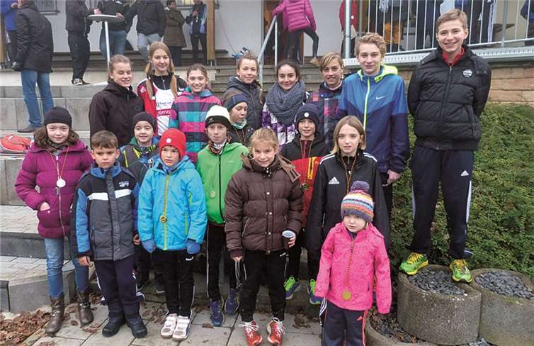 Strahlende Gesichter der jungen TV-Leichtathletikmannschaft nach Abschluss einer erfolgreichen Teilnahme an den Crosslauf-Wettbewerben (v.li.): Lena Pintscher, David Uhle, Marie Raueiser , Luis Pintscher, Daria Schiefelbein, Mathis Mohr, Lilli Balles, Lucas Raueiser, Sarah Gräf, Kerstin Henrichs, Celina Esper, Sophia Oberkirch, Lennart Mohr, Hanna Görgen, Josi Balles, Nesthäckchen Frieda, Jens Mildenberg und Julian Olbermann. privat