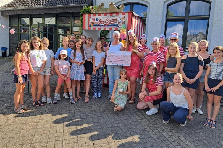 Symbolische Scheckübergabe bei der Eisparty in Morenhoven durch Vorstandsmitglied Ingrid Contempree an die Vorsitzende des Damenkomitees, Michelle Sühl.