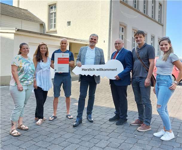 Symbolische Schlüsselübergabe von Manfred Diehl, Vorsitzender des Verwaltungsrates der Pfarrei Heilig Kreuz, an Geschäftsleitung und Mitarbeitende des Caritas-Migrationsdienstes. Foto: Marco Wagner