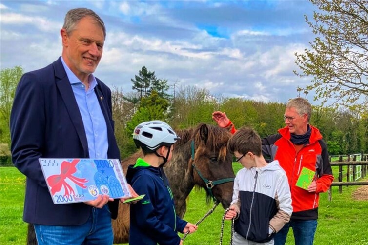 Symbolischer Scheck fürs „Ponycamp“ (von links nach rechts: Präsident Karl Böttcher (LIons Cub Meckenheim-Wachtberg), Schüler Jack und Matteo, Pastpräsiden Georg Persch (Lions Club Bonn-Rhenobacum