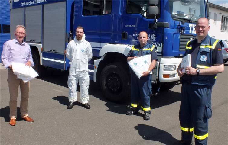 THW-Ortsbeauftragter Björn Harrenberger, dessen Stellvertreter Tobias Schenkelberg (r.) und THW-Notfalllogistiker Axl Feige (mit Schutzanzug) zeigten sich dankend erfreut über das Geschenk ihres Bundestagsabgeordneten.Foto: Reinhard Vanderfuhr / Büro Rüddel