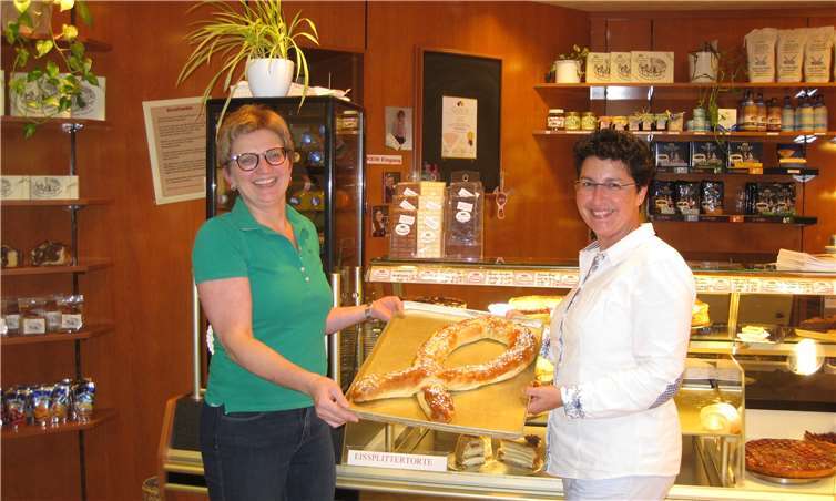 Tamara Bünnagel (rechts), Pflegeexpertin für Brustkrebserkrankungen, und Petra Schmitz (links) zeigen eine der leckeren Hefeschleifen, die ab Oktober in der Bäckerei Schmitz zum Verkauf stehen. Privat