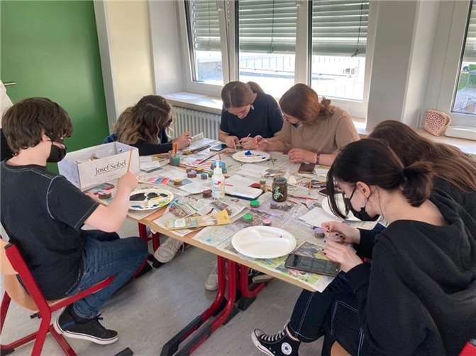 Tatkräftig basteln die Schülerinnen und Schüler an den Mosaikstücken der Friedenstaube.