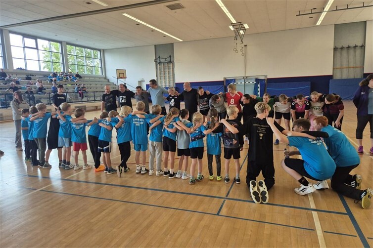 Teamgeist über alle Generationen hinweg: Zum Abschluss des Handballcamps trafen die jungen Handballer auf Eltern und Trainer. Vor den gemeinsamen Spielen schworen sich alle im großen Kreis ein – ein besonderer Moment, der den Zusammenhalt innerhalb der HSV-Familie zeigt.
