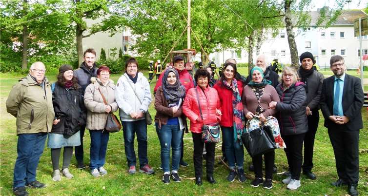 Teamleiter Bernd Berenz (3.v.l.) und Elke Heiß (3.v.r.) erklärten den Asylanten das Brauchtum, Bürgermeister Wolfgang Lambertz (r.) unterstützte seine Feuerwehrleute..  Ulli Burkholz