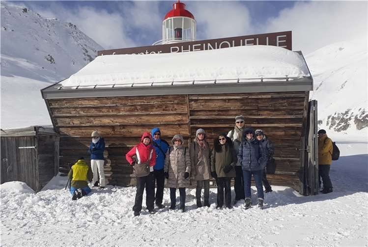 Teilnehmende der Fahrt im Schnee vor dem Infocenter Rheinquelle und dem dort stehenden kleinen Leuchtturm.