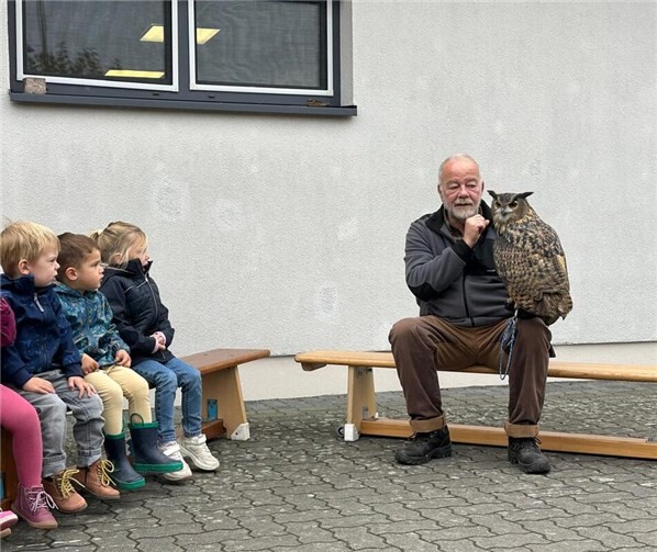 „Theo, Leron und Anni mit Eule Emma“: Die Kids dürfen aus nächster Nähe Eule Emma betrachten.