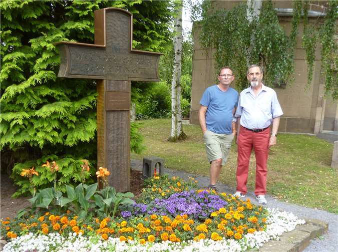 Theo Verdegen und Harry Sander (v.l.) vor dem Grabkreuz der Familie Karsten. Foto: -AB-