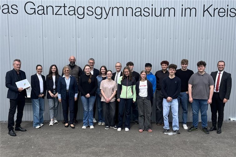 Thomas J. Portugall, Kendra Schaup, Claudia Perser, Gabriele Lapport, Christian Mirbach, Peter Mohr (von links), Udo Lohner (Mitte) und René Schell (rechts) gratulieren den Preisträgerinnen und Preisträgern des Wettbewerbs Mathematik ohne Grenzen 2026 