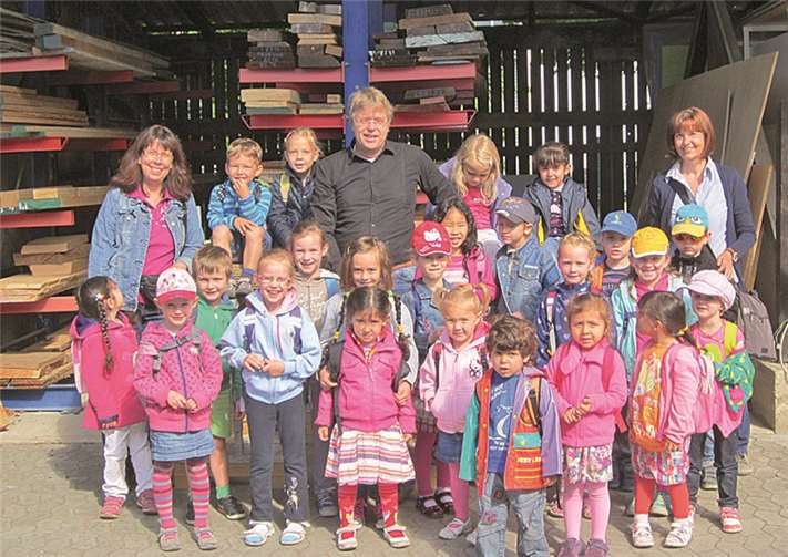 Thomas Radermacher im Kreise der Kita-Kinder und der Erzieherinnen vor seiner Schreinerei. Stadt Meckenheim