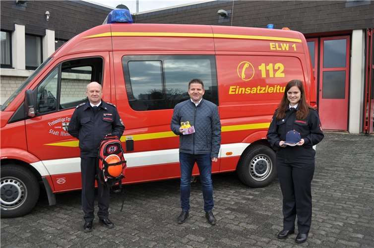 Thomas Rähse (Links) und Sarah Wiegershaus, Leitende der Jugendfeuerwehr Meckenheim, erhalten von Bürgermeister Holger Jung (Mitte) ein Sparschwein mit 500 Euro. Foto: Stadt Meckenheim