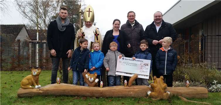 Thorsten Schneider und Henning Wulf vom Karthäuser Bürgerverein übergeben den symbolischen Spendenscheck an Jessica Merz und Dennis Neis, die vom Nikolaus und einigen Kindern unterstütz wurden.Quelle: Karthäuser Bürgerverein