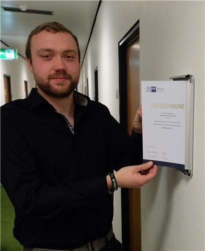 Tim Betz bringt die Urkunde an, mit der die IHK die Stadtverwaltung als Ausbildungsbetrieb ausgezeichnet hat. Foto: privat