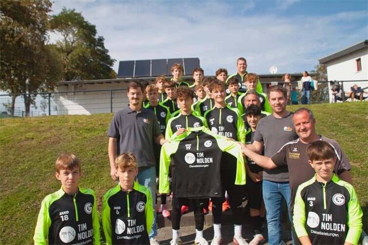 Tim und Ron Nolden mit der C1 Jugend und Michael Sämmer von der Jugendleitung bei der Übergabe