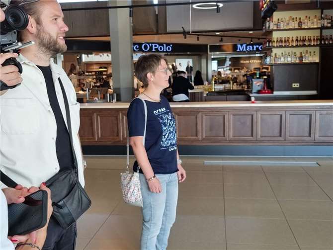 Tina wartet voller Vorfreude am Ankunftsterminal auf Joshua.