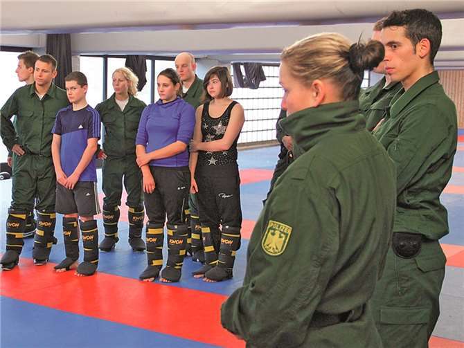 Tobias Reetz, Annika Lingscheid und Jasmin Seidel (v.l.) lauschen im Kreis ihrer Lehrgruppe den Ausführungen des Polizeitrainers. Bundespolizei