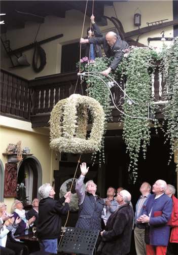 Toni Reif, Inhaber des Weinguts Antoniushof, zieht mit einem Sangesbruder die Krone auf.