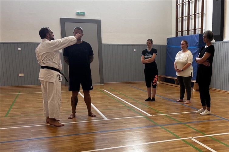 Trainer Peter Büttner (links) zeigt interessierten Einsteigern Karate-Techiken.