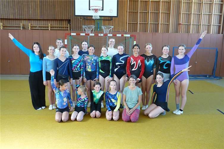 Trainerin Beate Wingender mit ihren Turnerinnen in nostalgischen Turntrikots.  Foto: privat