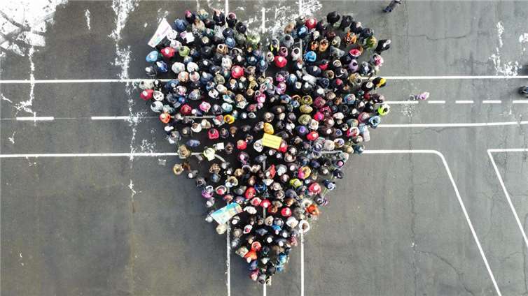 Über 300 Menschen versammelten sich auf dem Kirmesplatz in Niederelbert, um gemeinsam ein riesiges Herz zu formen. Foto: Initiative „Niederelbert für…“