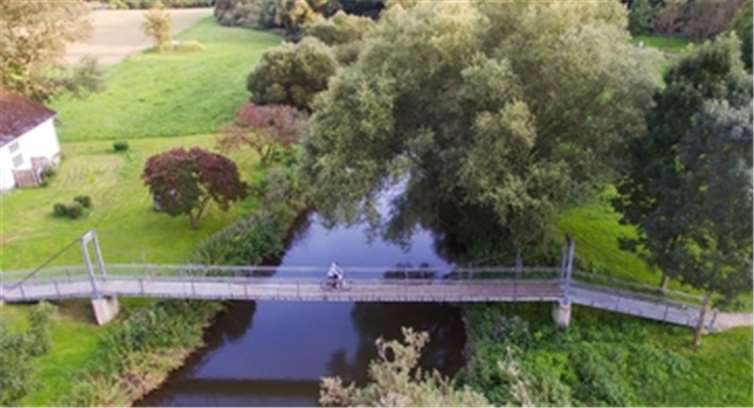 Über Brücken und entlang des Ufersfolgt der Radweg den Schleifen der Wied.