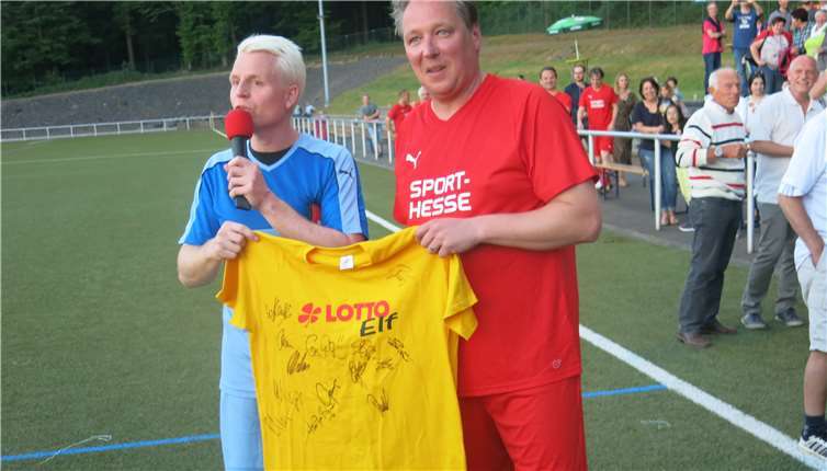 Über ein signiertes Lotto-Elf-Trikot aus den Händenvon Guido Cantz freut sich Mitorganisator Dirk Metternich.