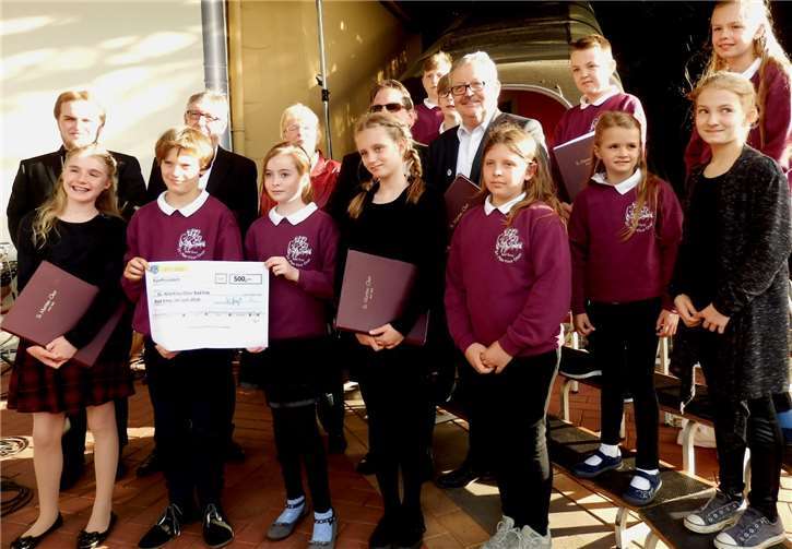 Über einen Scheck über 500 Euro freuen sich die Kinder des St.-Martins-Chores. privat