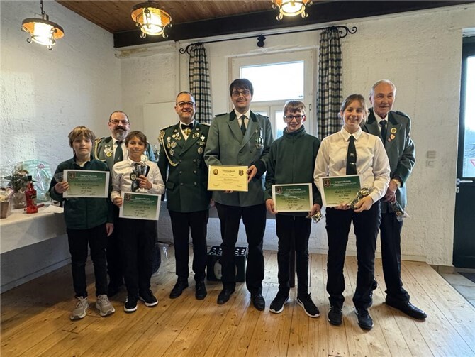 Übergabe der Jubiläumsnadel und Urkunde, Nadeln zur Jugend-Vereinsmeisterschaft und Schützenschnüre v. l. Luis Reichmann, Jungschützenmeister Mario Kröll, Matthias Kröll, Brudermeister Alexander Knopp, Jubilar Sebastian Stümper, Felix Weidenbach, Maike Kröll und Ernst Josef Schlang