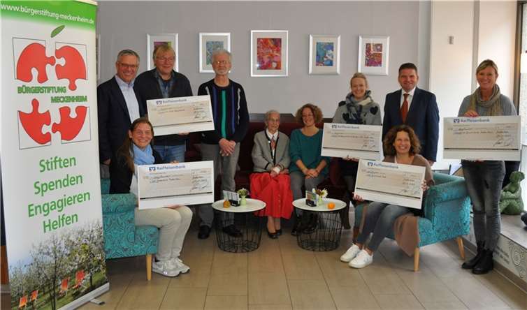 Übergabe der Spendenschecks, von links: Burchard Kraus, Stellvertretender Vorsitzende des Stiftungsvorstandes der Bürgerstiftung, Silke Brämm, Stellvertretende Leiterin der Katholischen Grundschule Meckenheim, Ulrich Kirsch, Musikalischer Leiter der Schulband der Geschwister-Scholl-Hauptschule, Klaus-Jürgen Pusch, Musikalische Begleitung und Technik, Initiatorin Erika Meyer zu Drewer, Mitglied des Stiftungsrates der Bürgerstiftung, Silvia Ibisch, Stellvertretende Leiterin der Geschwister-Scholl-Hauptschule, Silke Lex, Kommissarische Leiterin der Gemeinschaftsgrundschule Meckenheim-Merl, Bürgermeister Holger Jung, Vorsitzender der Stiftungsvorstandes der Bürgerstiftung, Maria Cloot, Leiterin der Katholischen Grundschule Merl, und Julia Gahl, Leiterin der Evangelischen Grundschule Meckenheim. Quelle: Bürgerstiftung Meckenheim