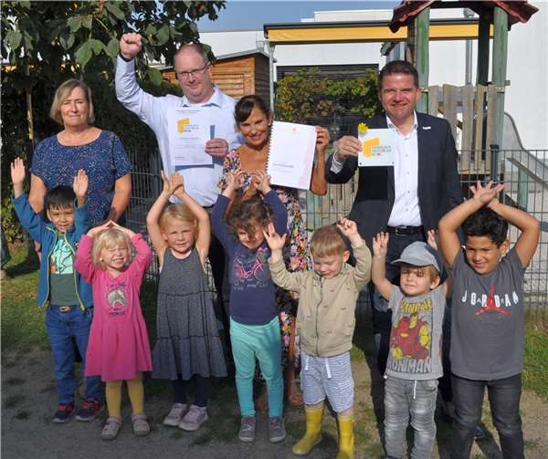 Übergabe des Zertifikates mit Kita-Kindern, hinten von links: Jaqueline Fischer-Leach, stellvertretende Leiterin des städtischen Familienzentrums Sonnengarten, Michael Ponath, Leiter des städtischen Familienzentrums Sonnengarten, Margit Bierbrauer, Fachberaterin der städtischen Kindertageseinrichtungen der Stadt Meckenheim, und Bürgermeister Holger Jung. Foto: Stadt Meckenheim