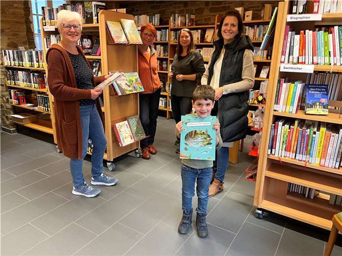 Ulla Häger, Jeany Sonneberger und Nicole Schachler (v. links) vom Team der Katholischen Öffentlichen Bücherei in Kesseling freuen sich über Leserinnen und Leser wie Christina Knebel mit ihrem Sohn Lennard.  Foto: Bistum Trier/Julia Fröder