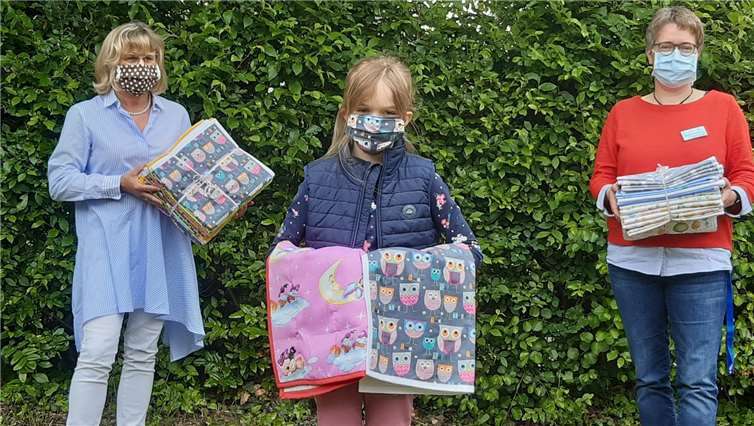 Ulrike Börder-Sauerbrei (links) und Elisabeth Paffhausen nehmen in gebührendem Abstand die wunderschönen Deckchen entgegen.Foto: Marienhaus Klinikum