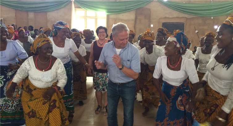 Ulrike Freisberg und ihr Mann Bernhardtanzen mit fröhlichen nigerianischen Menschen.