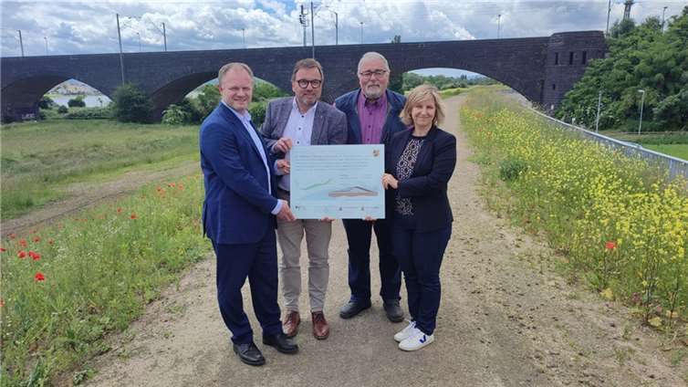 Umweltministerin Katrin Eder (re.) und SGD-Nord-Präsident Wolfgang Treis (2. v. li.) präsentierten gemeinsam mit Jan Einig (li.), Oberbürgermeister der Stadt Neuwied, und Johann-Dieter Neckenig (2. v. re.), Ortsvorsteher in Engers, die Infotafel für den sanierten Deich.  Foto: SGD Nord