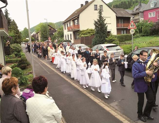 Unter Führung des Musikvereins Treis geleitete die Pfarrgemeinde die Erstkommunionkinder von der Hinter-Mont-Straße zur Pfarrkirche St. Johannes d. T.MT