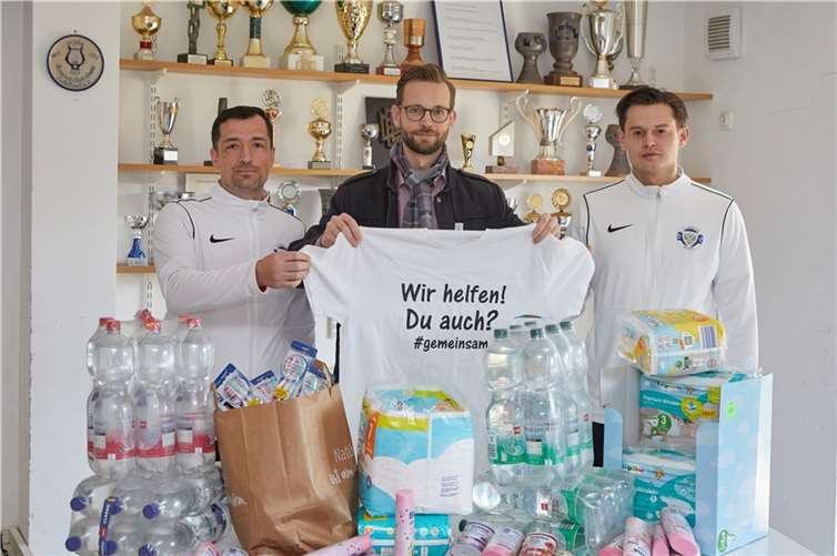Unter dem Motto „Wir helfen! Du auch? #gemeinsam“ sammelt der FC Lokomotive Montabaur derzeit Sachspenden für Flüchtlinge und die Ukraine. Unterstützt wird die Hilfsaktion unter anderem von Bürgermeister Ulrich Richter-Hopprich (Mitte), der den Vorsitzenden Nikita Bitner (rechts) und Alexander Samonin (rechts), Abteilungsleiter Fußball, im Sportlerheim in Eschelbach besuchte. Quelle: VG Montabaur