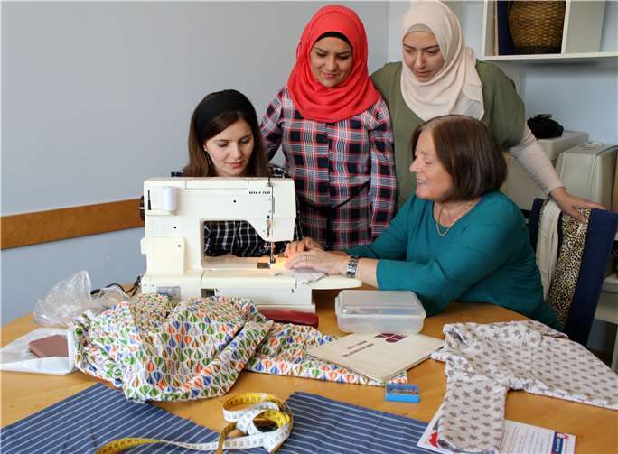 Unter der Anleitung von Margot Rube (vorne rechts) lernen Flüchtlingsfrauen bei den regelmäßigen Begegnungstreffen in Montabaur den richtigen Umgang mit der Nähmaschine.Caritasverband Montabaur