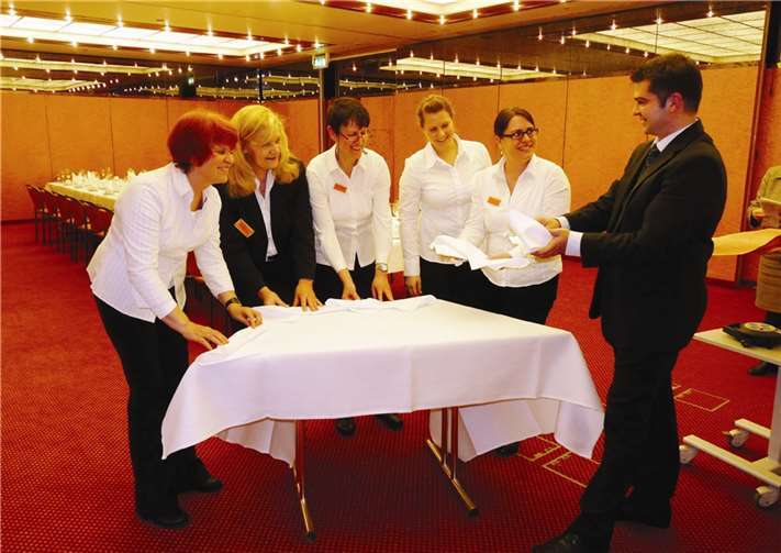 Unter der fachkundigen Leitung des Restaurantchefs Matthias Locher erlernen die Pädagoginnen der Partnerschulen das kunstvolle Falten von Servietten. SF