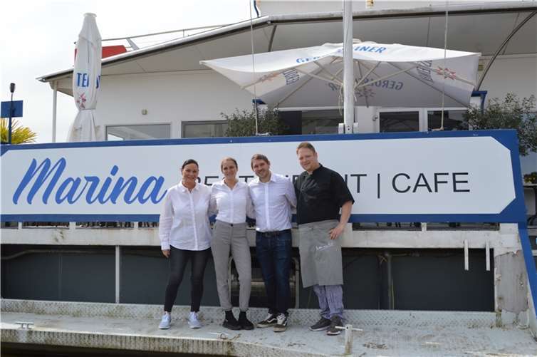 Unternehmerin Laura Weiß (2.v.l.) mit Ehemann Thorben Weiß (2.v.r.), dem Küchenchef und einer Mitarbeiterin vor der Terrasse zum Restaurant-Cafe Marina. Foto: AB